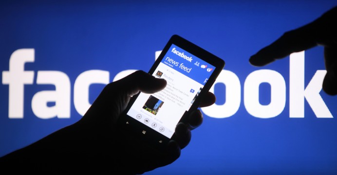 A smartphone user shows the Facebook application on his phone in the central Bosnian town of Zenica, in this photo illustration, May 2, 2013. Facebook Inc's mobile advertising revenue growth gained momentum in the first three months of the year as the social network sold more ads to users on smartphones and tablets, partially offsetting higher spending which weighed on profits. REUTERS/Dado Ruvic (BOSNIA AND HERZEGOVINA - Tags: SOCIETY SCIENCE TECHNOLOGY BUSINESS)